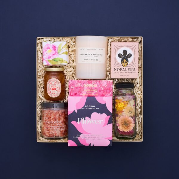 floral products inside a gift box on a navy blue background.